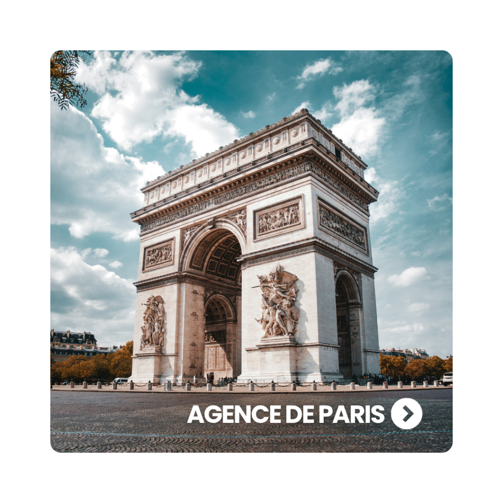 L'Arc de Triomphe de l'Étoile à Paris photographié depuis la chaussée sous un ciel légèrement nuageux.