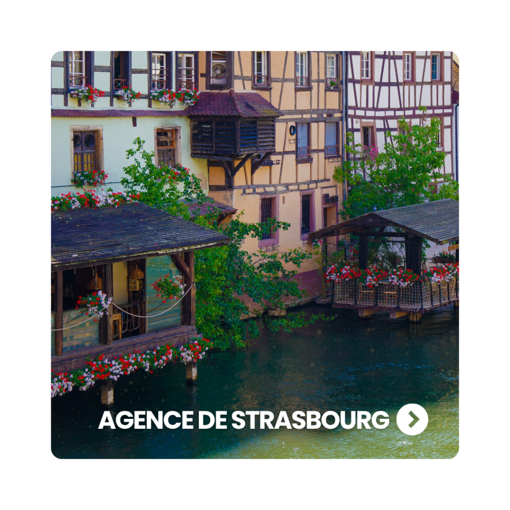 Façades de maisons à colombages au bord de l'eau ornées de fleurs dans le quartier de la Petite France à Strasbourg.